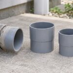 屋外の排水管と大きさの異なる灰色のソケットを並べた様子