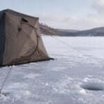 氷上のワカサギテントをロープとアイスペグで固定している様子