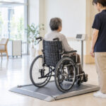 介護施設で車椅子に乗ったまま体重計に載る利用者と職員