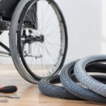 車いすのそばに交換用タイヤと工具を並べた様子