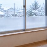 雪景色が見える窓の下部に半透明の断熱パネルを設置した室内