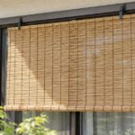窓の外側にフックですだれを掛けた住宅の窓辺