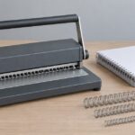 ワイヤー閉じ機と厚さの異なる製本リングを机上に並べた様子