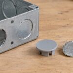 配線ボックスの丸穴と複数種類の穴塞ぎ部品を並べたイメージ