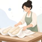 パン生地をクープ布にのせて発酵させるパン職人をイメージしたイラスト
